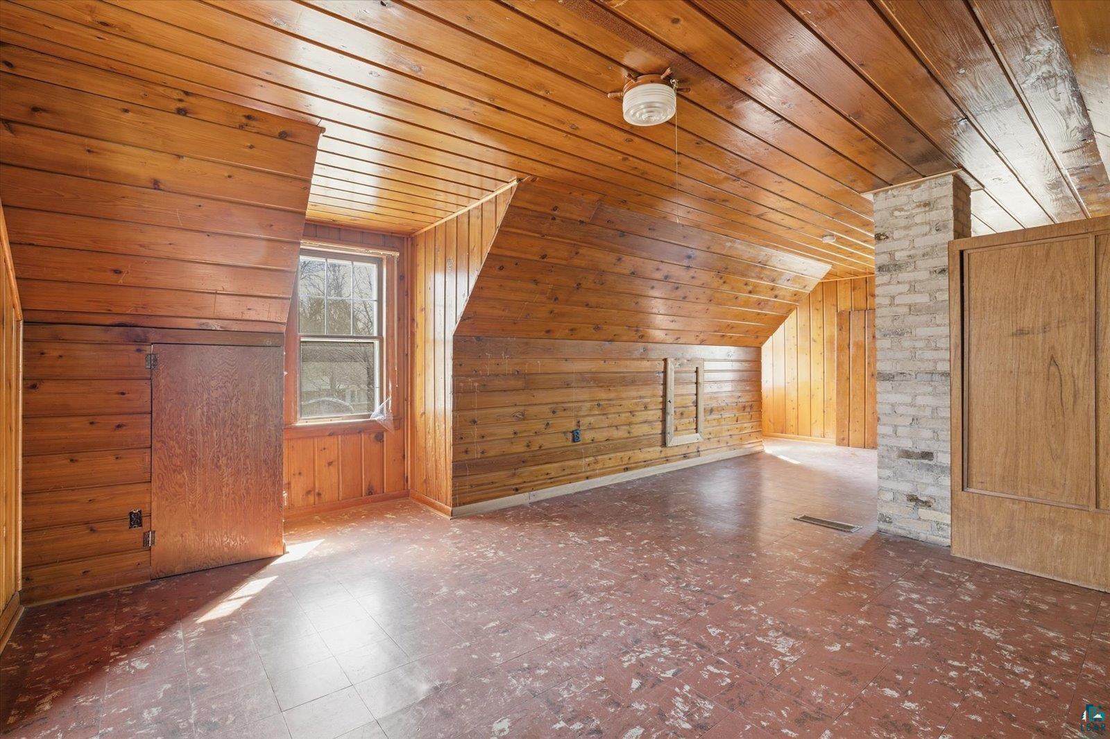 709 Michigan Street Hibbing, MN 55746 - Photo 16 of 47 Bonus room featuring wood walls, tile patterned floors, and a vaulted wood ceiling