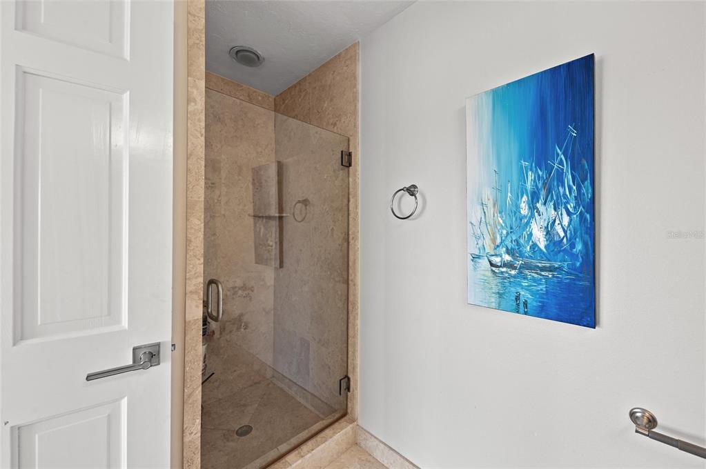 140 North Casey Key Road Osprey, FL 34229 - Photo 37 of 91 a bathroom with a glass shower door