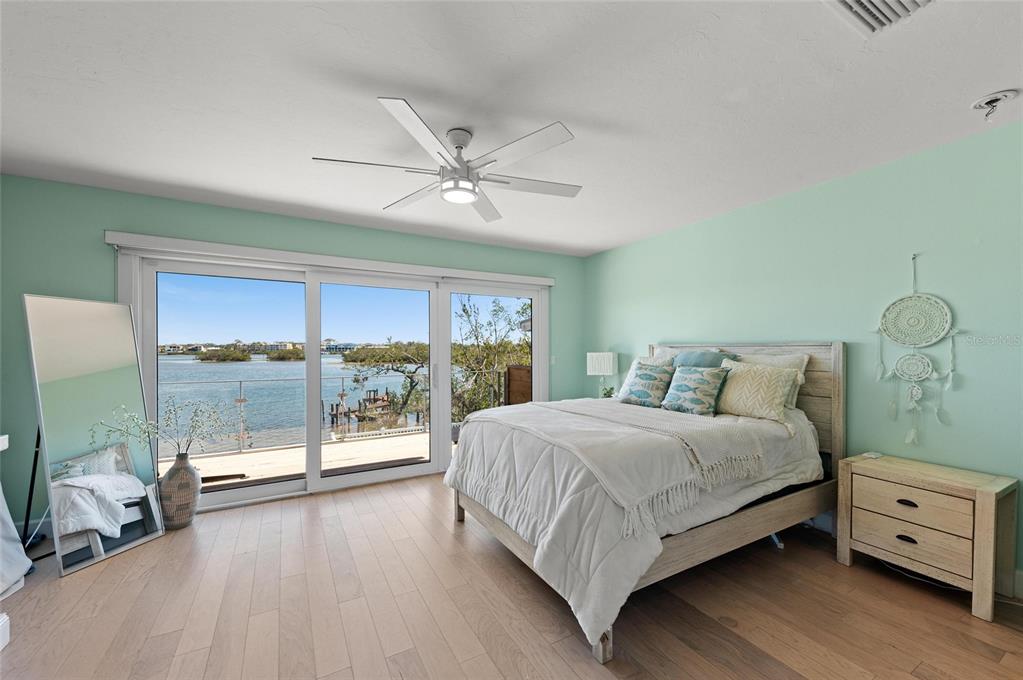 140 North Casey Key Road Osprey, FL 34229 - Photo 45 of 91 a bedroom with a large bed and a chandelier fan