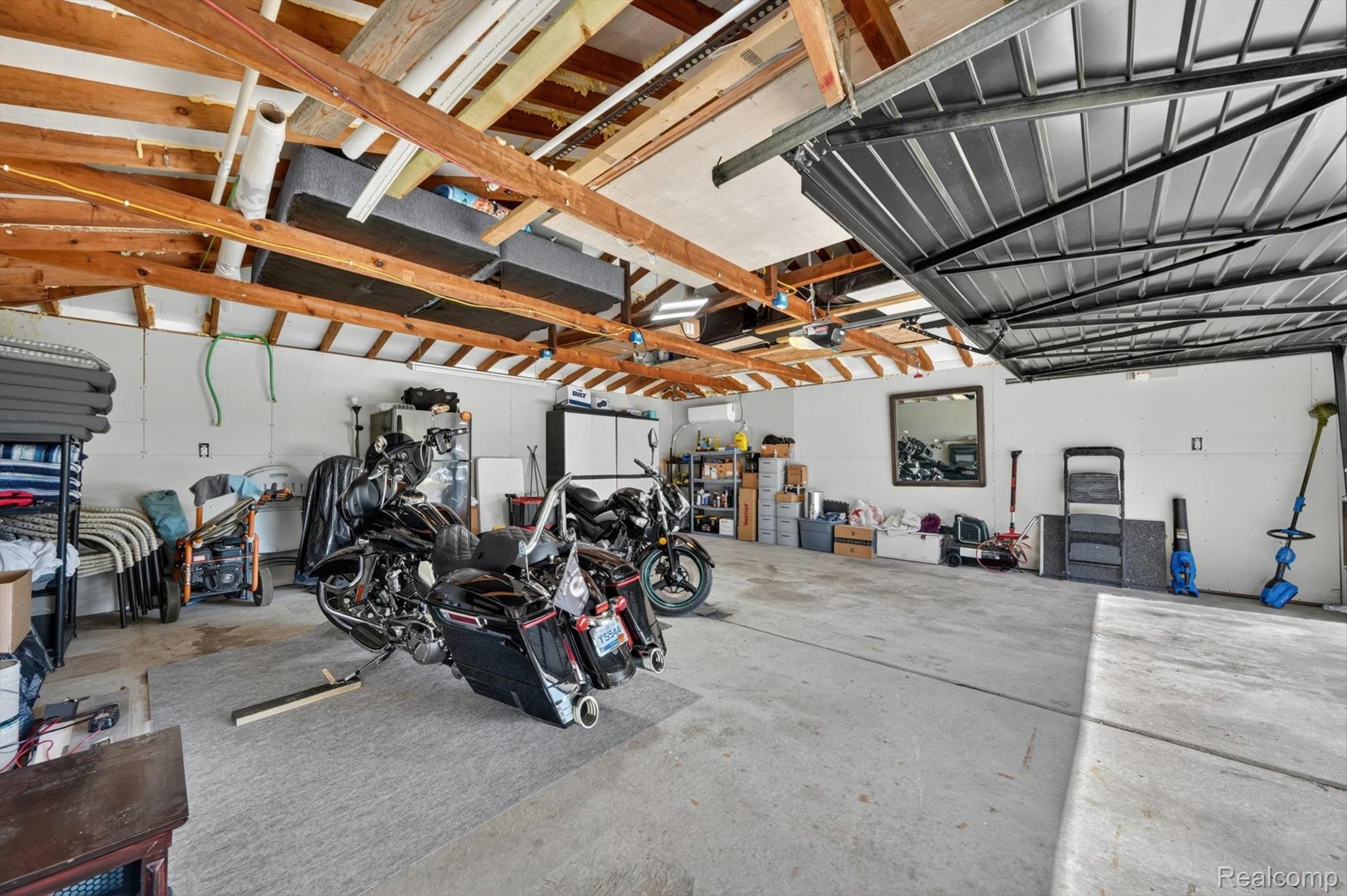 2861 John R Road Rochester, MI 48307 - Photo 40 of 54 Spacious garage featuring a concrete floor, exposed wood beam ceiling, and white painted walls