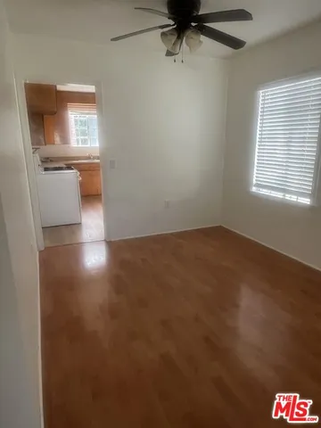 an empty room with a window and a chandelier fan