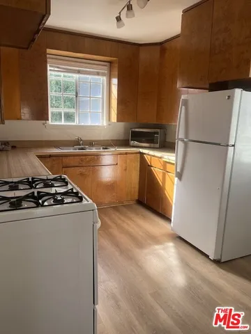 a kitchen with a stove a refrigerator and a sink