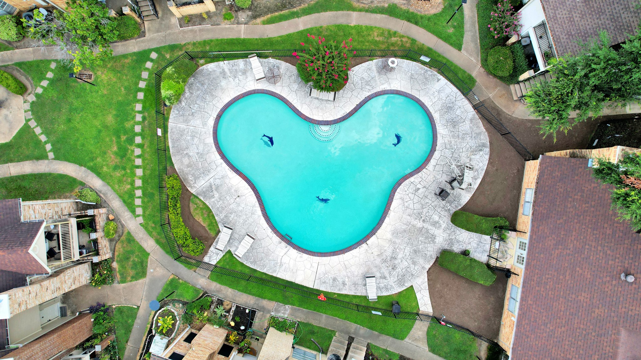 an aerial view of a swimming pool with outdoor seating and yard