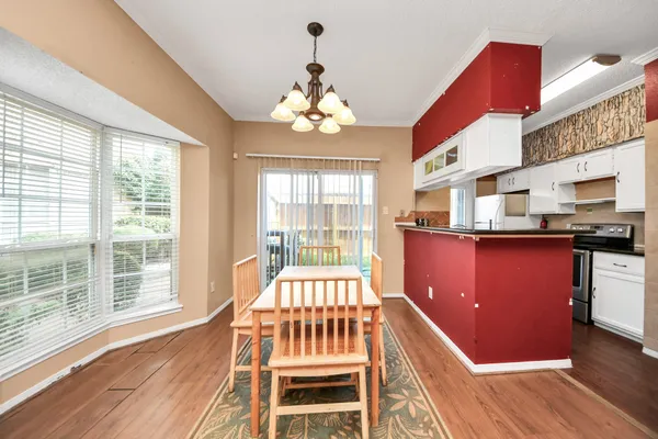 a view of a dining room with furniture a chandelier and wooden floor
