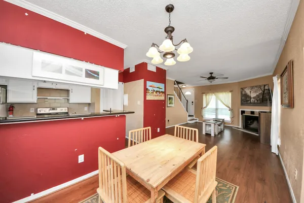 a view of a dining room with furniture a chandelier and wooden floor