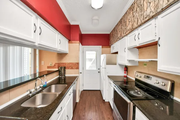 a kitchen with stainless steel appliances granite countertop a sink stove and cabinets