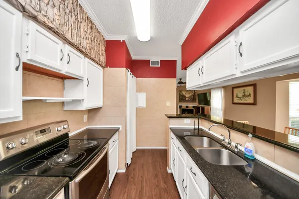 a kitchen with stainless steel appliances granite countertop a sink and a stove