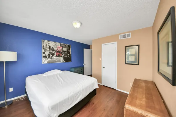 a bedroom with a bed and a painting on the wall