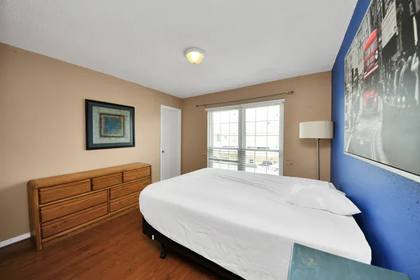 a bedroom with a bed and a dresser next to a window