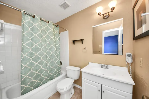 a bathroom with a sink a toilet and shower curtain