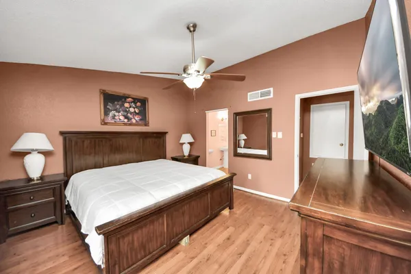 a bedroom with a large bed and a chandelier