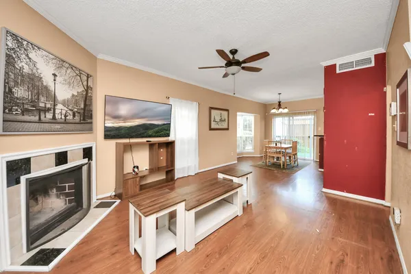 a living room with furniture a fireplace and wooden floor