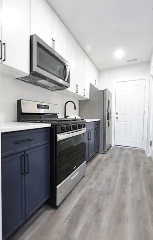 a kitchen with stainless steel appliances granite countertop a sink stove and refrigerator