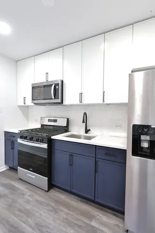 a kitchen with stainless steel appliances a sink a stove and a refrigerator