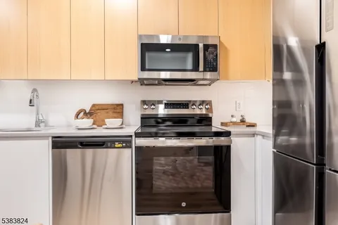 a kitchen with stainless steel appliances granite countertop a stove a refrigerator and a microwave