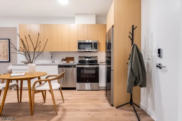 a kitchen with stainless steel appliances kitchen island granite countertop a refrigerator and a stove top oven