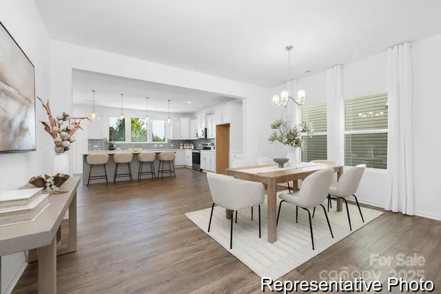 a dining room with furniture potted plants and wooden floor
