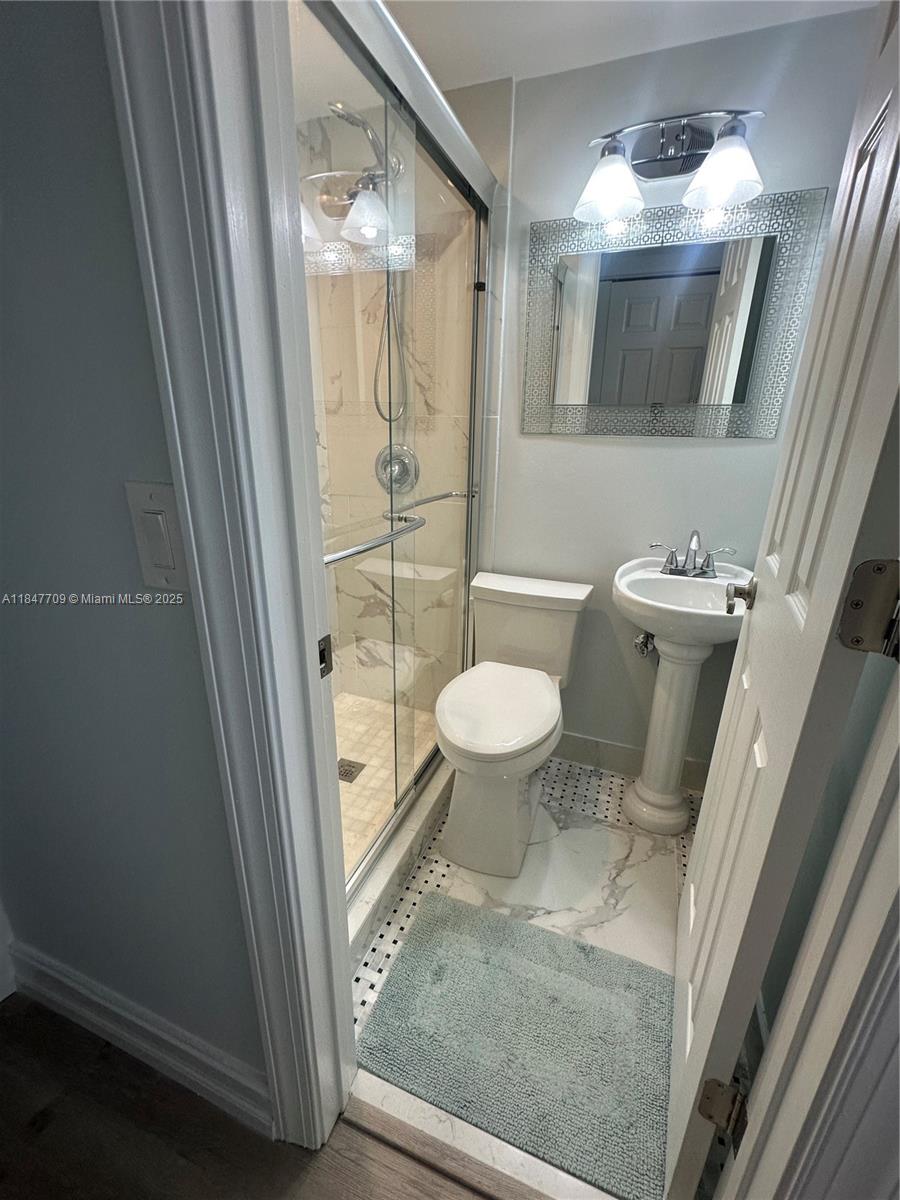 4027 Swansea Crescent, Unit 4027 Deerfield Beach, FL 33442 - Photo 23 of 47 a bathroom with a toilet a sink and a mirror