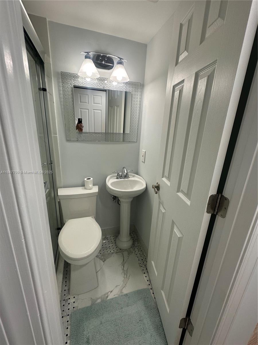 4027 Swansea Crescent, Unit 4027 Deerfield Beach, FL 33442 - Photo 24 of 47 a bathroom with a toilet sink and mirror