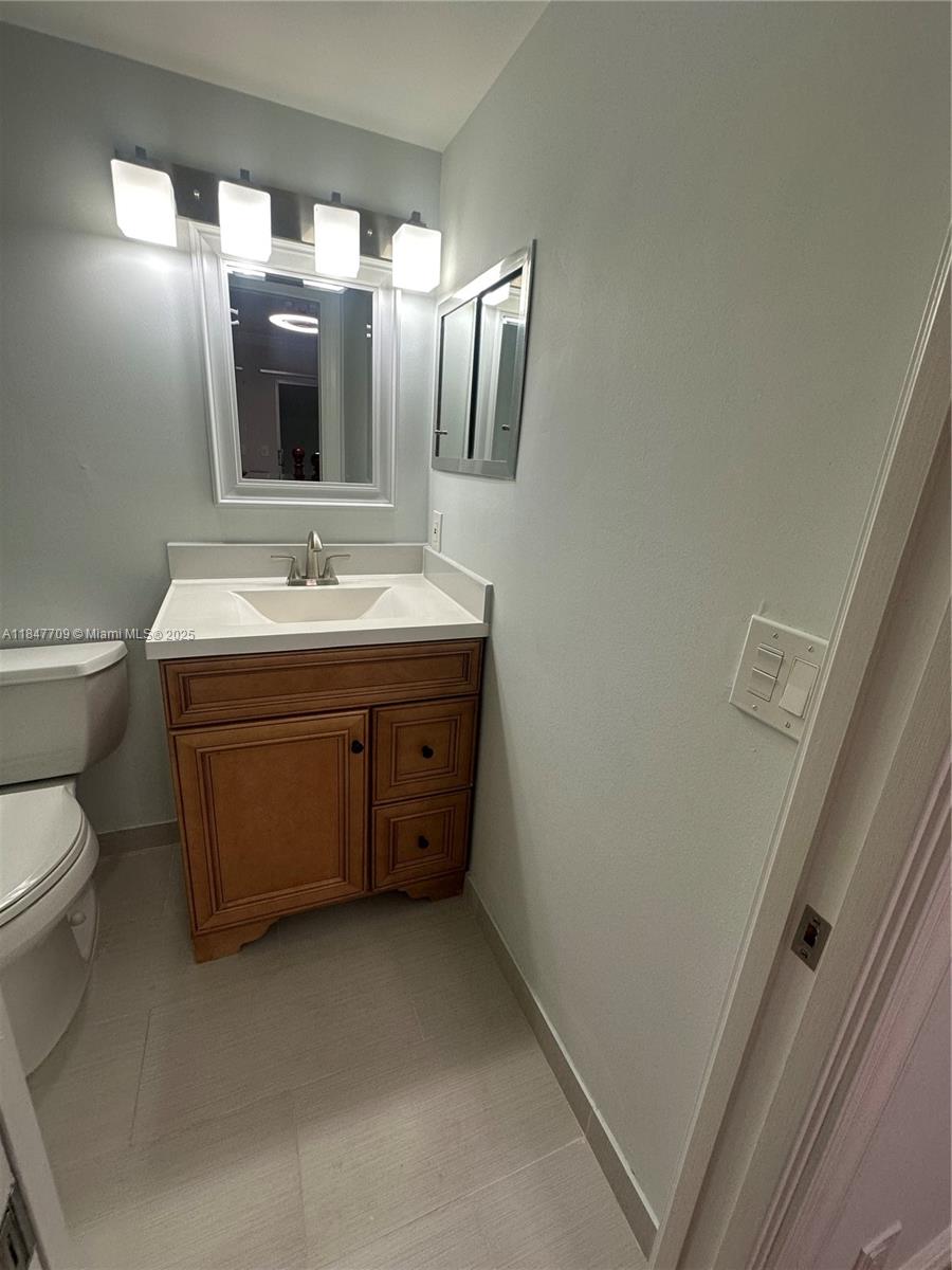 4027 Swansea Crescent, Unit 4027 Deerfield Beach, FL 33442 - Photo 32 of 47 a bathroom with a toilet sink and mirror