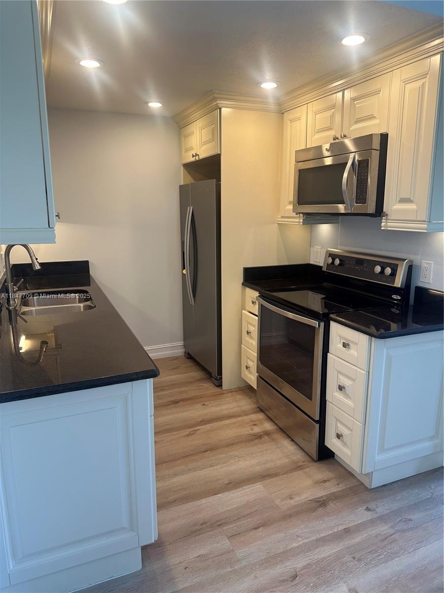 4027 Swansea Crescent, Unit 4027 Deerfield Beach, FL 33442 - Photo 10 of 47 a kitchen with stainless steel appliances a stove microwave and refrigerator