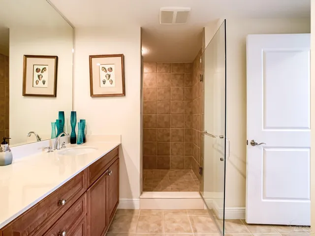 a bathroom with a granite countertop sink mirror and shower