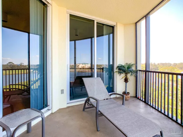 a view of a balcony and chair and floor to ceiling window