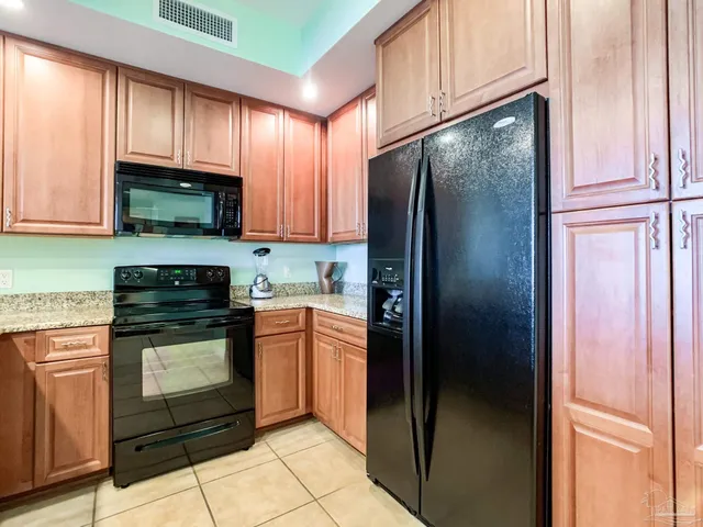 a kitchen with granite countertop a refrigerator stove and microwave