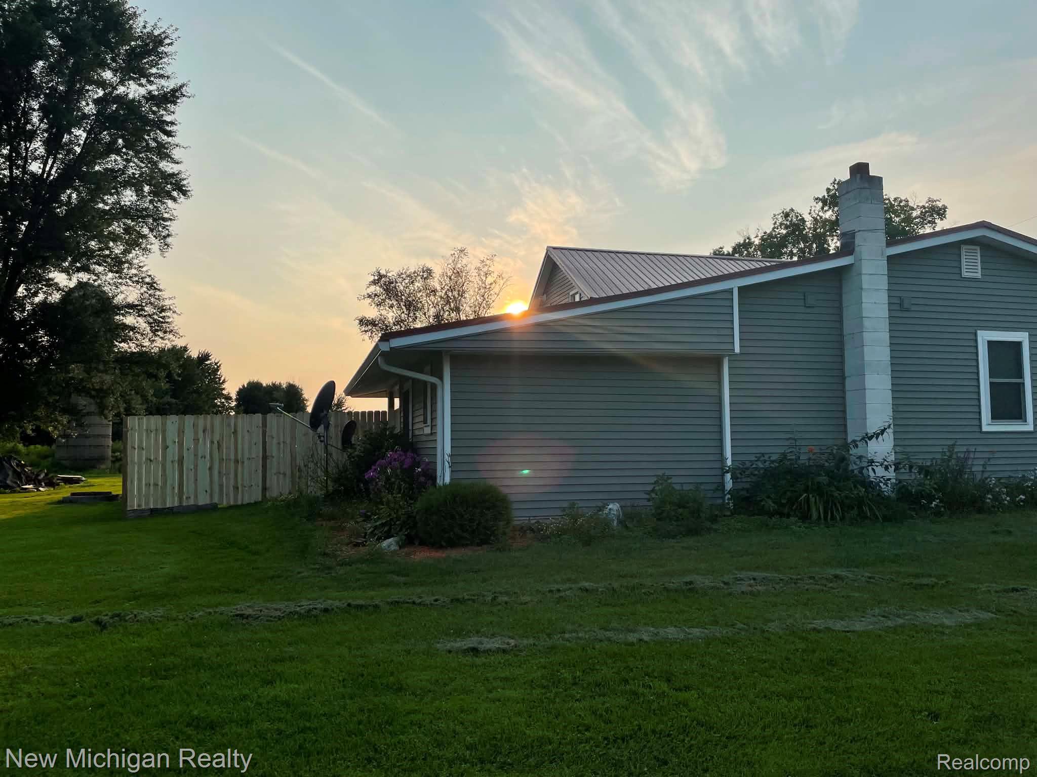 7415 Farrand Road Clio, MI 48420 - Photo 2 of 31 Exterior featuring horizontal siding, a metal roof, and a stone chimney