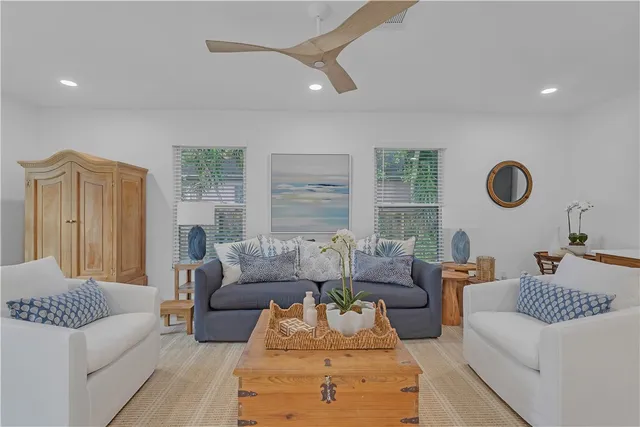 a living room with dining table and a chandelier