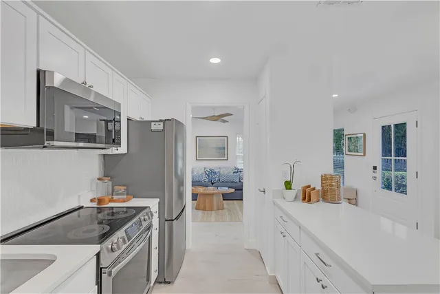 a kitchen with stainless steel appliances granite countertop a refrigerator and a stove top oven