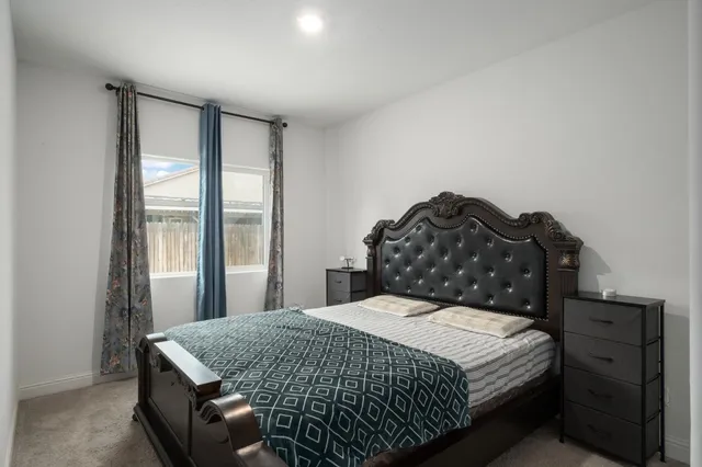 a bedroom with a bed and dresser with mirror