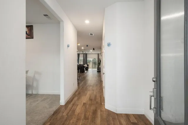 a view of a hallway with wooden floor