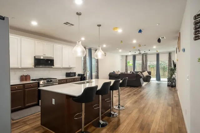 a large kitchen with stainless steel appliances lots of counter space and a wooden floors