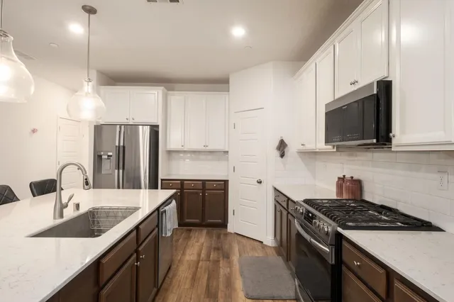 a kitchen with stainless steel appliances granite countertop a sink stove and refrigerator