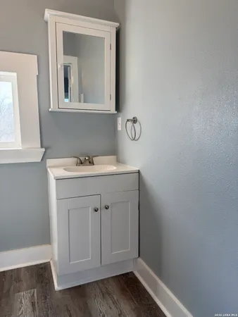 a bathroom with a sink vanity and a mirror