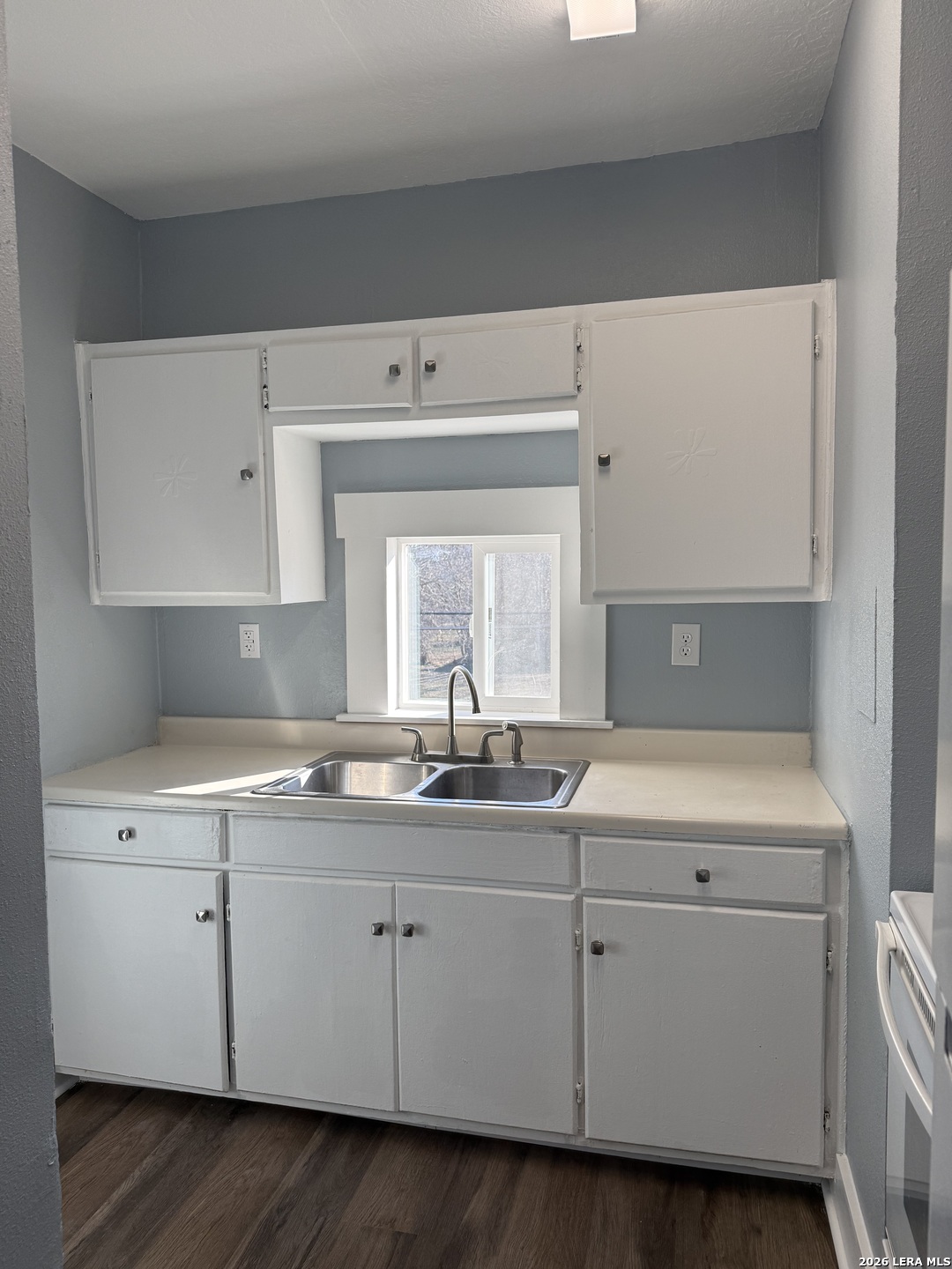 917 South 4th Street Temple, TX 76504 - Photo 20 of 33 a kitchen with granite countertop white cabinets and white appliances