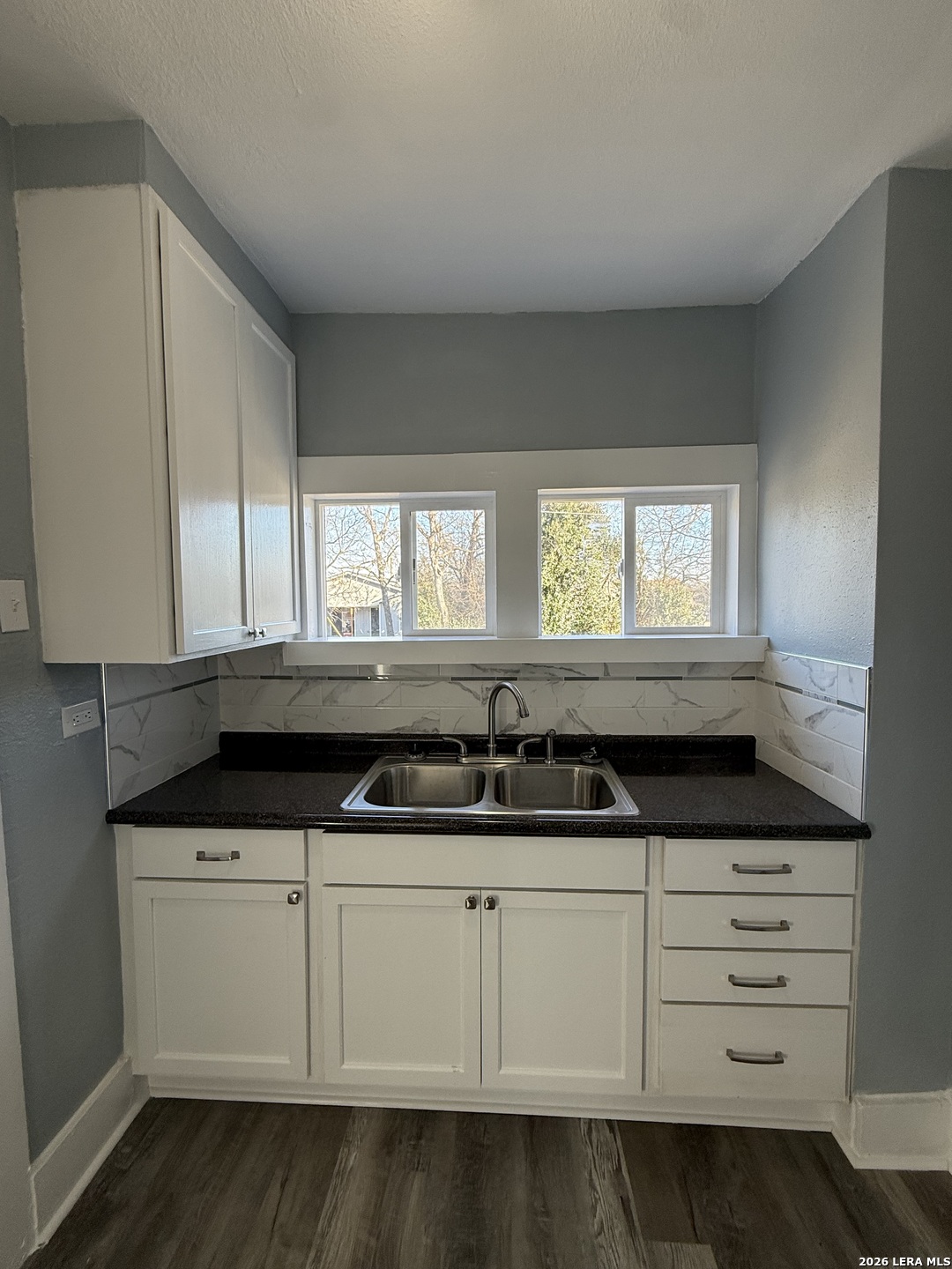 917 South 4th Street Temple, TX 76504 - Photo 27 of 33 a kitchen with granite countertop a sink and a white cabinets