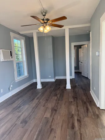a view of a livingroom with wooden floor and a ceiling fan