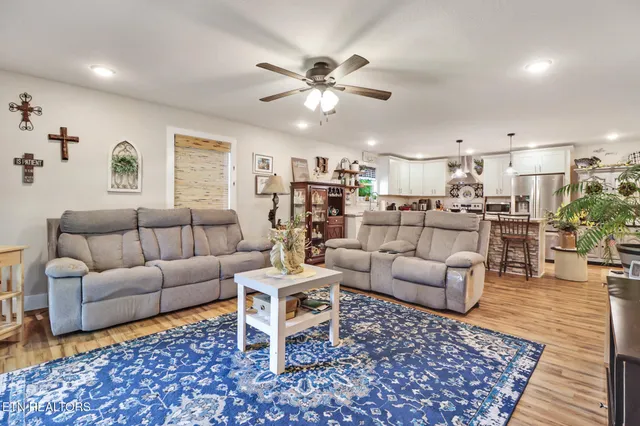a living room with furniture and a view of kitchen