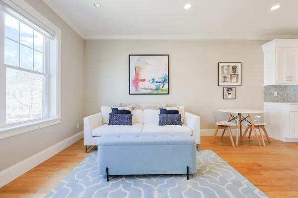 a living room with couches a coffee table and next to a window