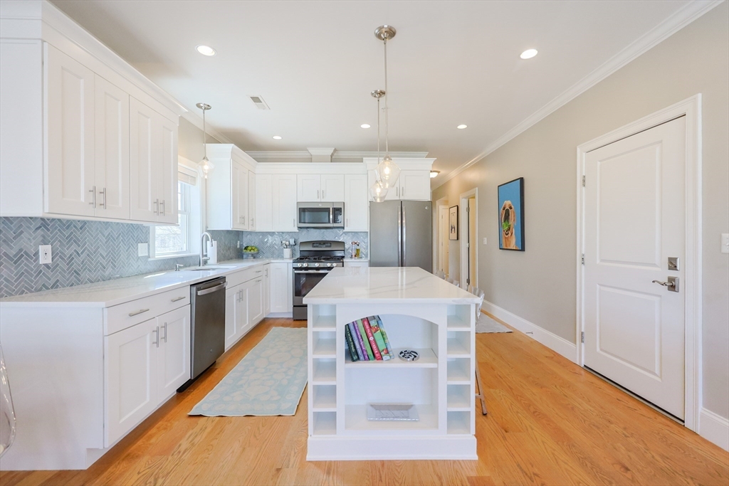 17 Washington Avenue, Unit 3 Waltham, MA 02453 - Photo 15 of 38 a white kitchen with wooden floor and stainless steel appliances