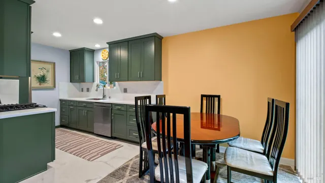 a kitchen with a table chairs sink and refrigerator