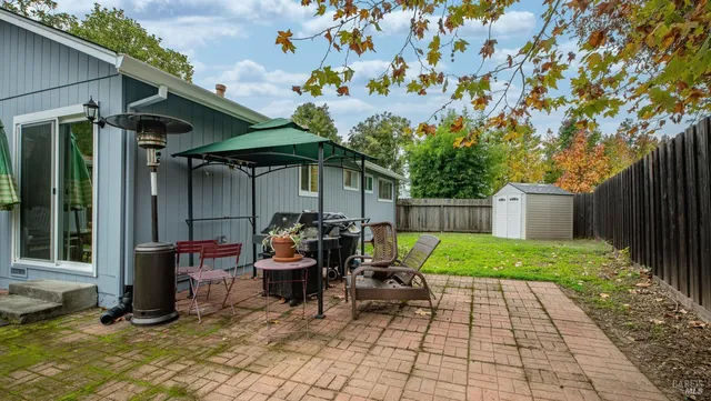 a view of a backyard with large trees and wooden fence