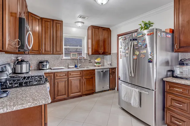 a kitchen with stainless steel appliances granite countertop a refrigerator sink and stove