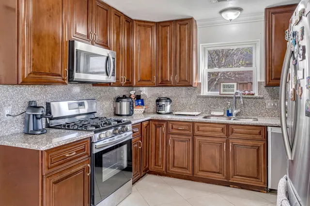 a kitchen with stainless steel appliances granite countertop a sink stove and cabinets