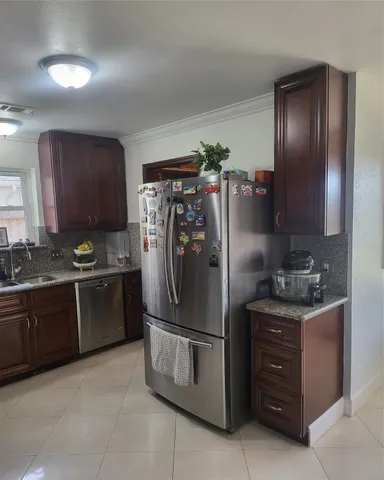 a kitchen with stainless steel appliances granite countertop a refrigerator and a stove