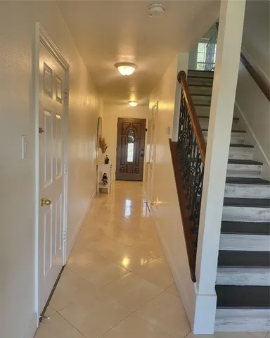 a view of a hallway with wooden floor and stairs