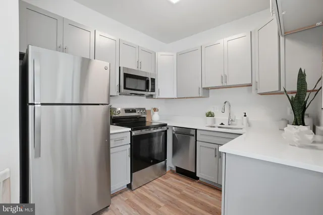 a kitchen with cabinets stainless steel appliances and a counter space
