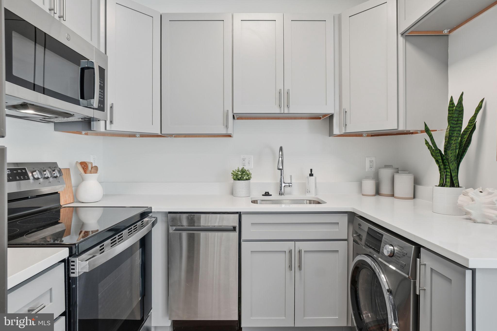 1451 Park Road Northwest, Unit 114 Washington, DC 20010 - Photo 7 of 23 a kitchen with stainless steel appliances granite countertop white cabinets sink and stove